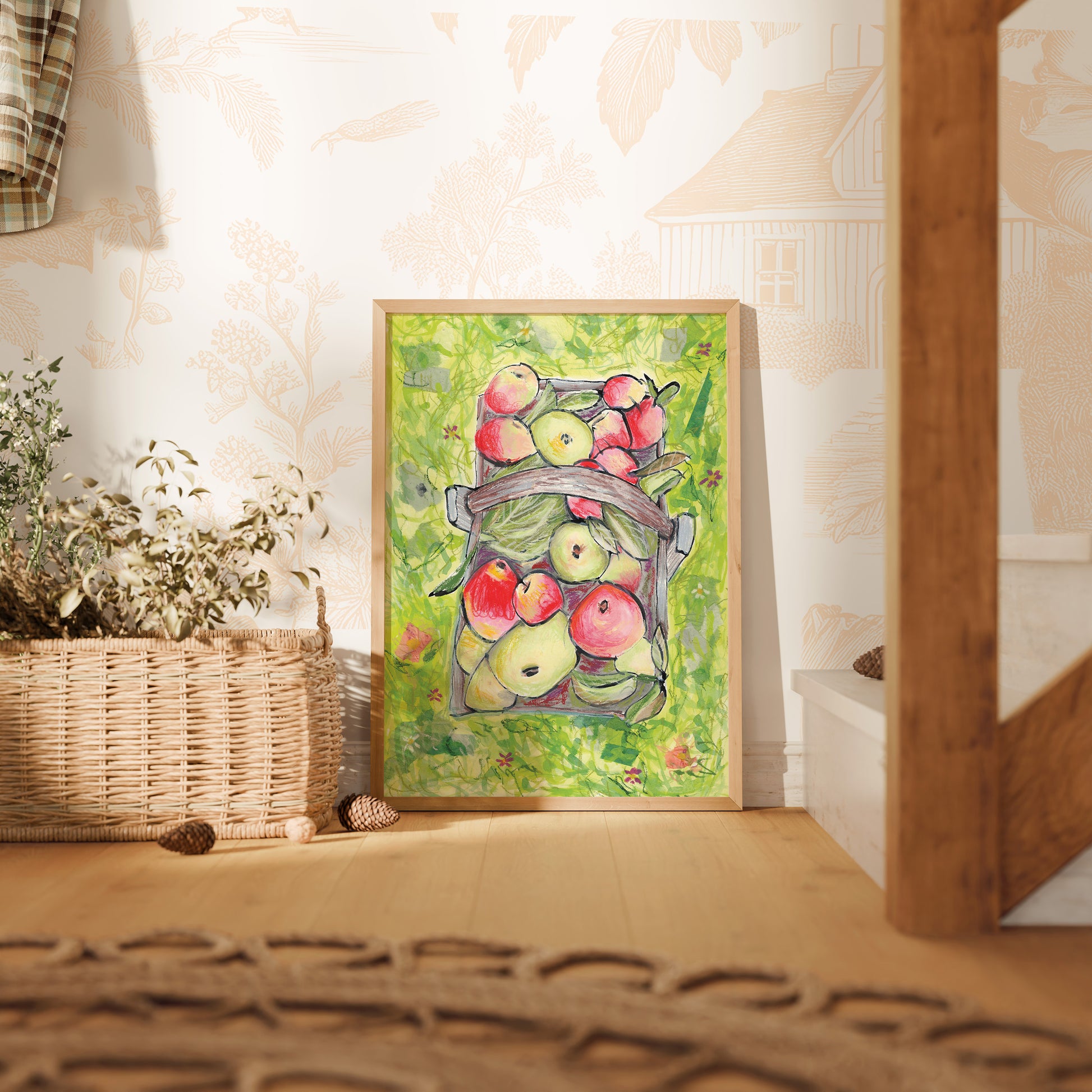Framed artwork of apples on a wall next to a woven basket