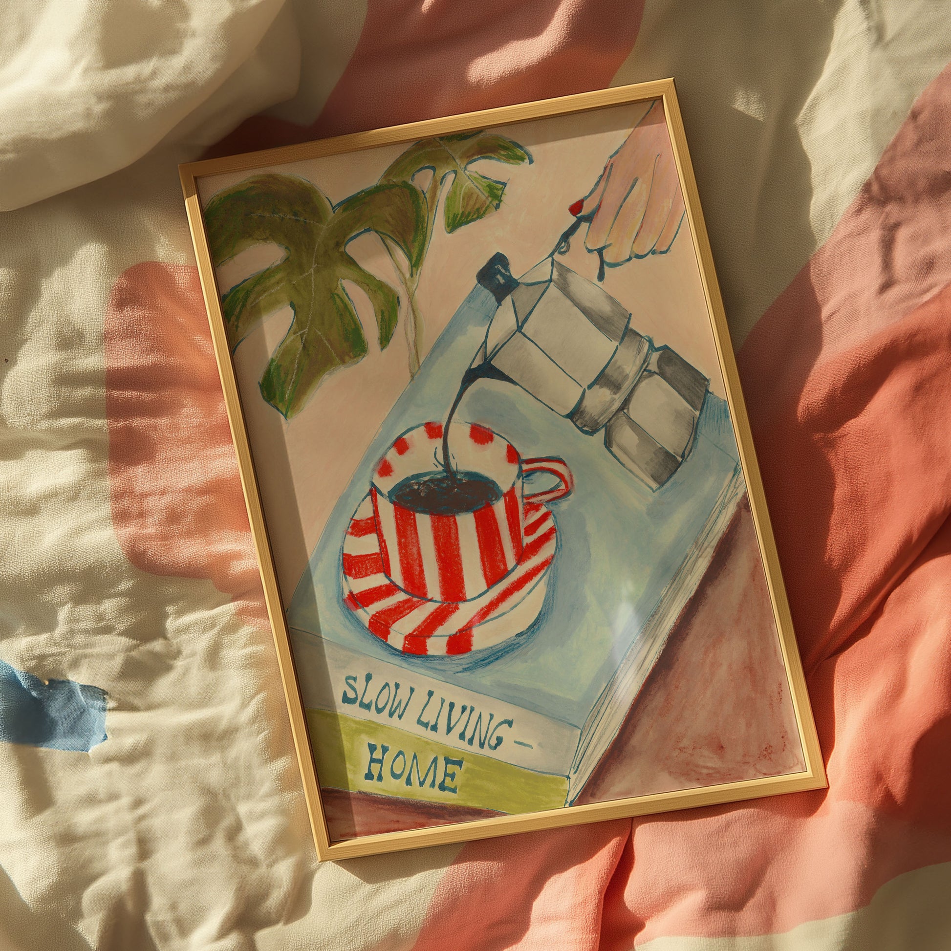 Framed artwork with a coffee cup and plant on a striped fabric