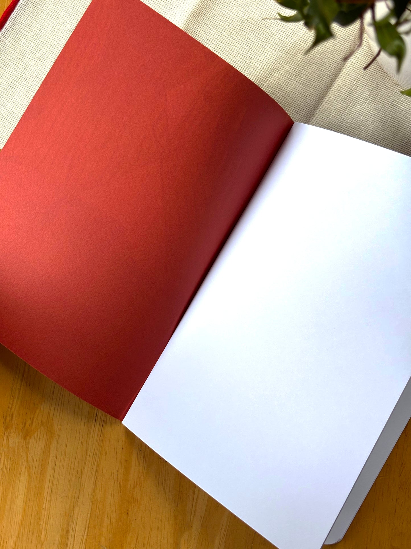Open book with terracotta cover and white pages on a wooden surface