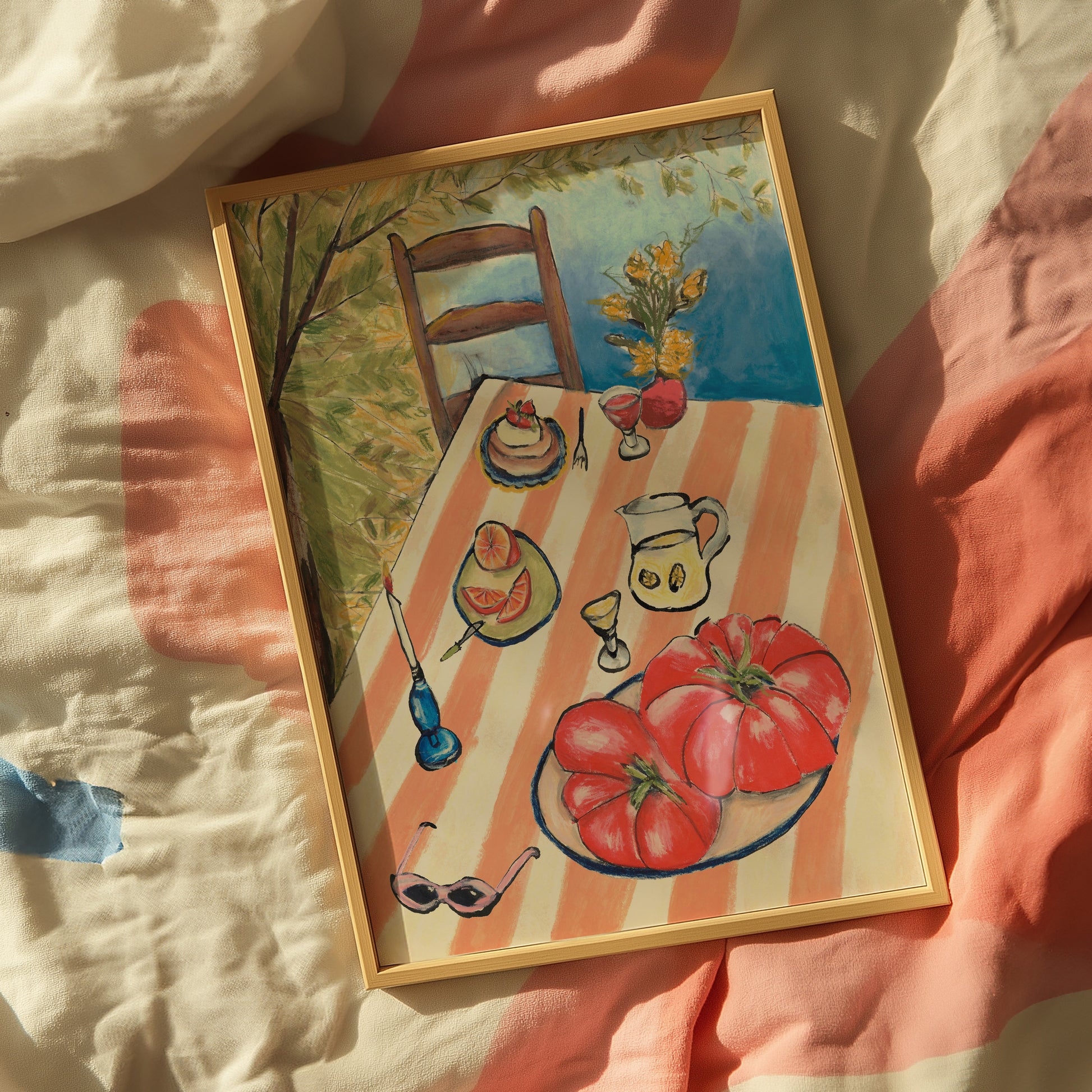 Framed artwork of a table setting with food and a chair on a striped fabric background