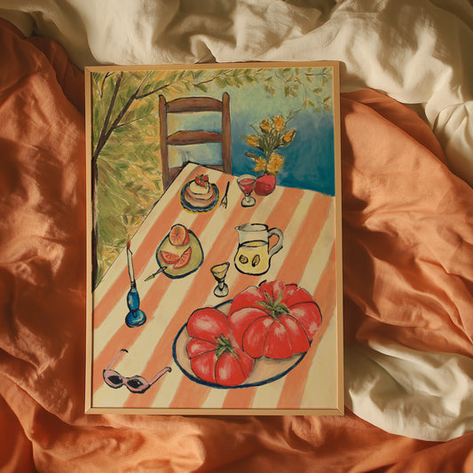 Framed painting of a table setting with tomatoes and other items on an orange fabric background