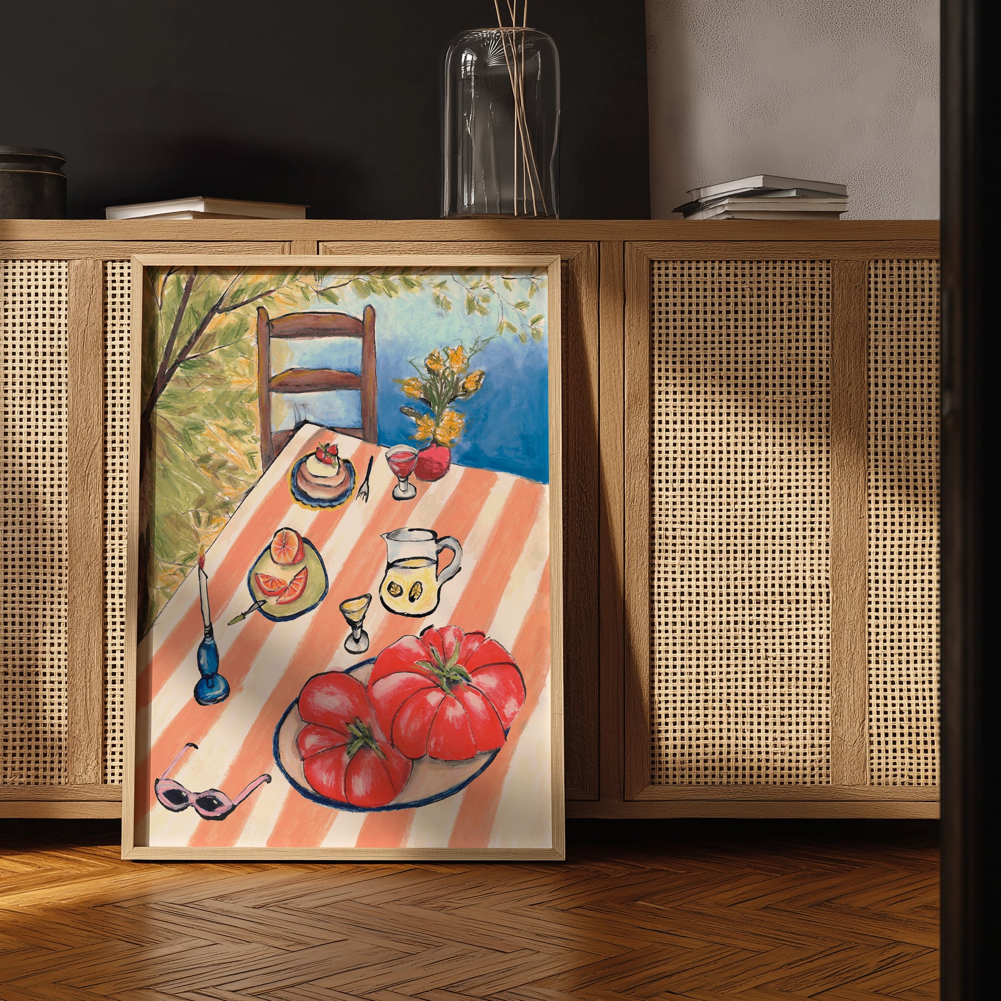 Framed painting of a table setting with tomatoes on a wooden shelf.