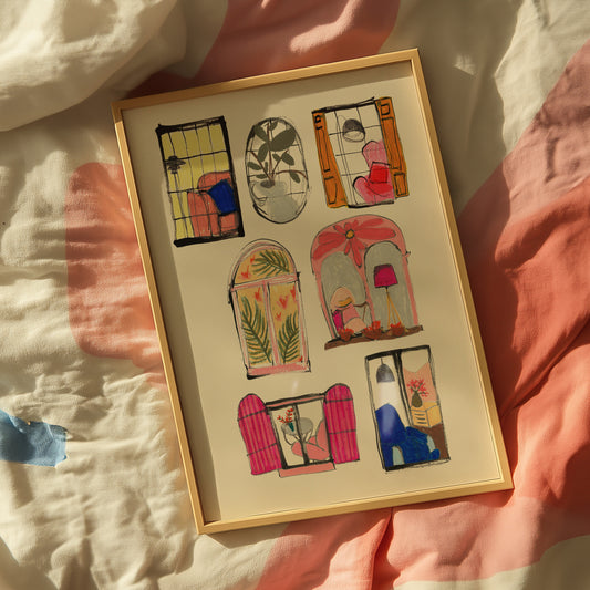 Framed artwork with colorful window designs on a soft fabric background