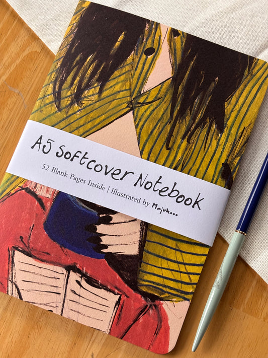 Notebook with abstract striped pyjama design and a pen on a wooden surface